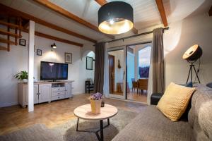 a living room with a couch and a tv at Beach Suite Nina in Rab
