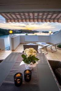 un jarrón de flores sobre una mesa en un balcón en Beach Suite Nina, en Rab