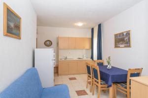 - une cuisine et une salle à manger avec une table et des chaises dans l'établissement apartmani Ivana, à Kaštela