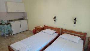 two beds in a small room with a kitchen at Kallirroi Studios in Pythagoreio +11 photos