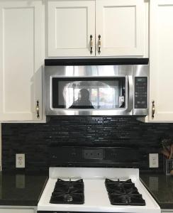 a microwave oven above a stove in a kitchen at Hollywood Stay in Los Angeles