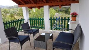 a patio with chairs and a table and a fence at Apartman Vojaline in Milna