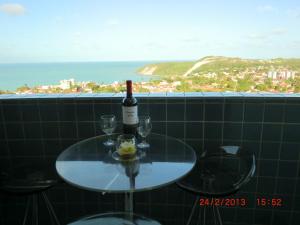 una mesa con una botella de vino y dos copas en Porto Tropical Residence, en Natal