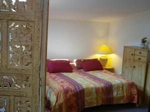 una camera da letto con un letto e una porta di legno di Appart'Hôtel Les Tilleuls a Saint-Macaire