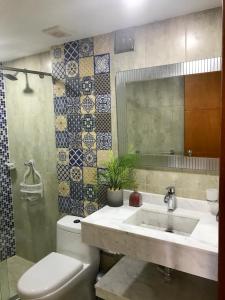 y baño con lavabo, aseo y espejo. en Apartamentos Cartagena Caribe Suite, en Cartagena de Indias