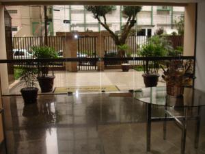 une table en verre dans une pièce avec des plantes en pot dans l'établissement Conforto, praticidade e seguranca!, à Curitiba