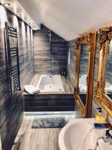 y baño con bañera, lavabo y espejo. en Luxury Apartment, en Blackpool