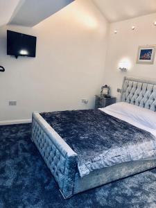 1 dormitorio con 1 cama grande y TV en la pared en Luxury Apartment, en Blackpool