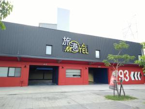 a red and black building with a sign on it at Travel Port Motel in Kaohsiung