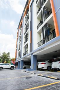 un estacionamiento con autos estacionados frente a un edificio en Be My Guest 36 en Bangkok