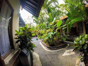 a courtyard with a bunch of plants in a house at Putu Guest House in Canggu