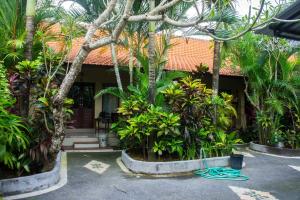 a house with a bunch of trees and plants at Putu Guest House in Canggu