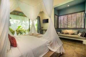 1 dormitorio con 1 cama blanca con mosquitera en Karmagali Suites Adults only & Private Pool Family Villas, en Sanur