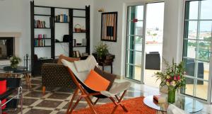 a living room with chairs and a table and windows at Tavira Terrace in Tavira