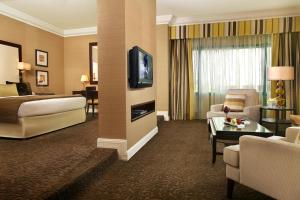 
a living room filled with furniture and a tv at Mövenpick Grand Al Bustan in Dubai
