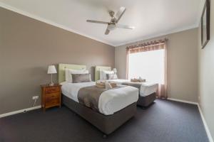 a bedroom with two beds and a ceiling fan at Tokemata Retreat in Cobram