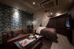 a hotel room with a couch and a bed at Restay Onoji (Adult Only) in Machida