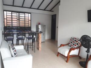 a living room with a table and chairs and a kitchen at La orquídea in El Cairo