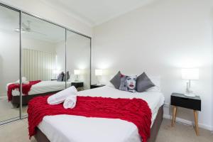 a bedroom with two beds and a red blanket at Cairns City Apartments in Cairns