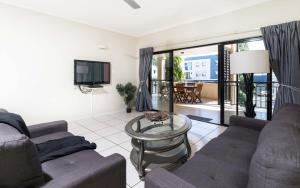 a living room with a couch and a glass table at Cairns City Apartments in Cairns