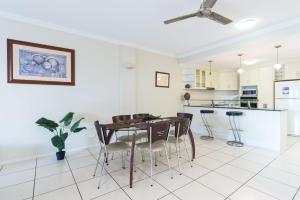 a kitchen and dining room with a table and chairs at Cairns City Apartments in Cairns
