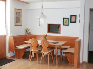 a dining room with a wooden table and chairs at Ferienapartmenthaus Hubertushof in Mittenwald
