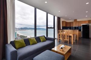 a living room with a blue couch and a kitchen at Holi Beach Hotel & Apartments in Nha Trang