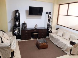 瓦拉斯Alojamiento Huaraz的带沙发和一些扬声器的客厅