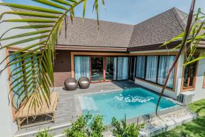 a villa with a swimming pool and a house at Triple Tree Beach Resort in Cha Am