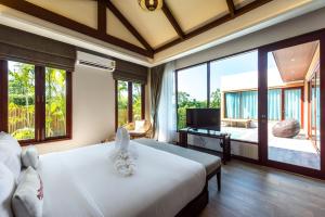 a bedroom with a large bed and large windows at Triple Tree Beach Resort in Cha Am +70 photos