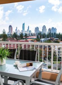 a dining room table with a balcony overlooking a city at Belle Maison Apartments - Official in Gold Coast