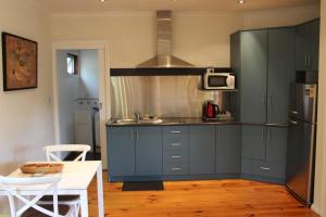 a kitchen with blue cabinets and a white table at Australian Home Away @ Wonga Park Brushy Creek in Wonga Park