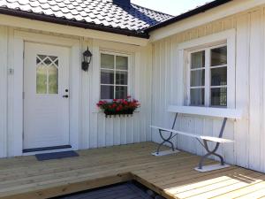 a porch with a white door and a bench at Göta kanal Hajstorp in Töreboda