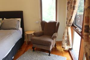 1 dormitorio con silla, cama y ventana en Australian Home Away @ Wonga Park Brushy Creek, en Wonga Park