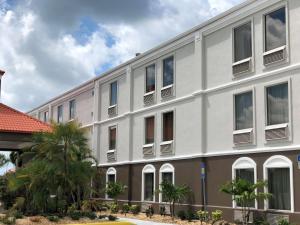 un edificio blanco con ventanas y palmeras en Best Western Plus Bradenton Hotel & Suites, en Bradenton