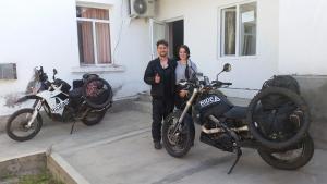 a man and a woman standing next to a motorcycle at Hostel Sharq 21 in Khujand