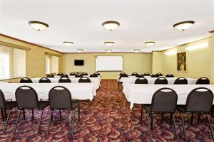 a conference room with white tables and black chairs at Microtel Inn & Suites by Wyndham Florence/Cincinnati Airpo in Florence