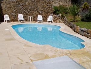 - une piscine avec des chaises et une table dans la cour dans l'établissement Hôtel Ker Izel Saint-Brieuc Centre Historique, à Saint-Brieuc