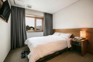 Postel nebo postele na pokoji v ubytování Busan Tourist Hotel