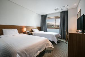 Postel nebo postele na pokoji v ubytování Busan Tourist Hotel