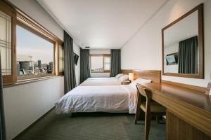 Postel nebo postele na pokoji v ubytování Busan Tourist Hotel
