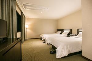 Postel nebo postele na pokoji v ubytování Busan Tourist Hotel