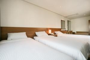 Postel nebo postele na pokoji v ubytování Busan Tourist Hotel