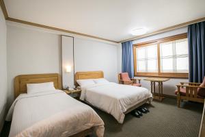 Postel nebo postele na pokoji v ubytování Busan Tourist Hotel