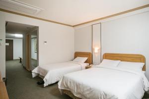 Postel nebo postele na pokoji v ubytování Busan Tourist Hotel