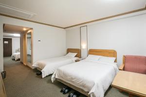 Postel nebo postele na pokoji v ubytování Busan Tourist Hotel