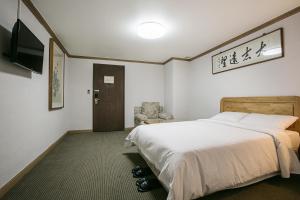 Postel nebo postele na pokoji v ubytování Busan Tourist Hotel