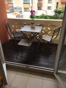 a table and chairs on a balcony with a table and flowers at Abbaye du Cap in Cap d'Agde