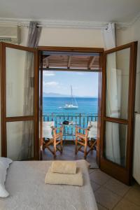 1 dormitorio con balcón con vistas al océano en SAGA Pension en Gytheio