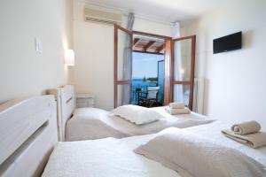 two beds in a room with a view of the ocean at SAGA Pension in Gythio